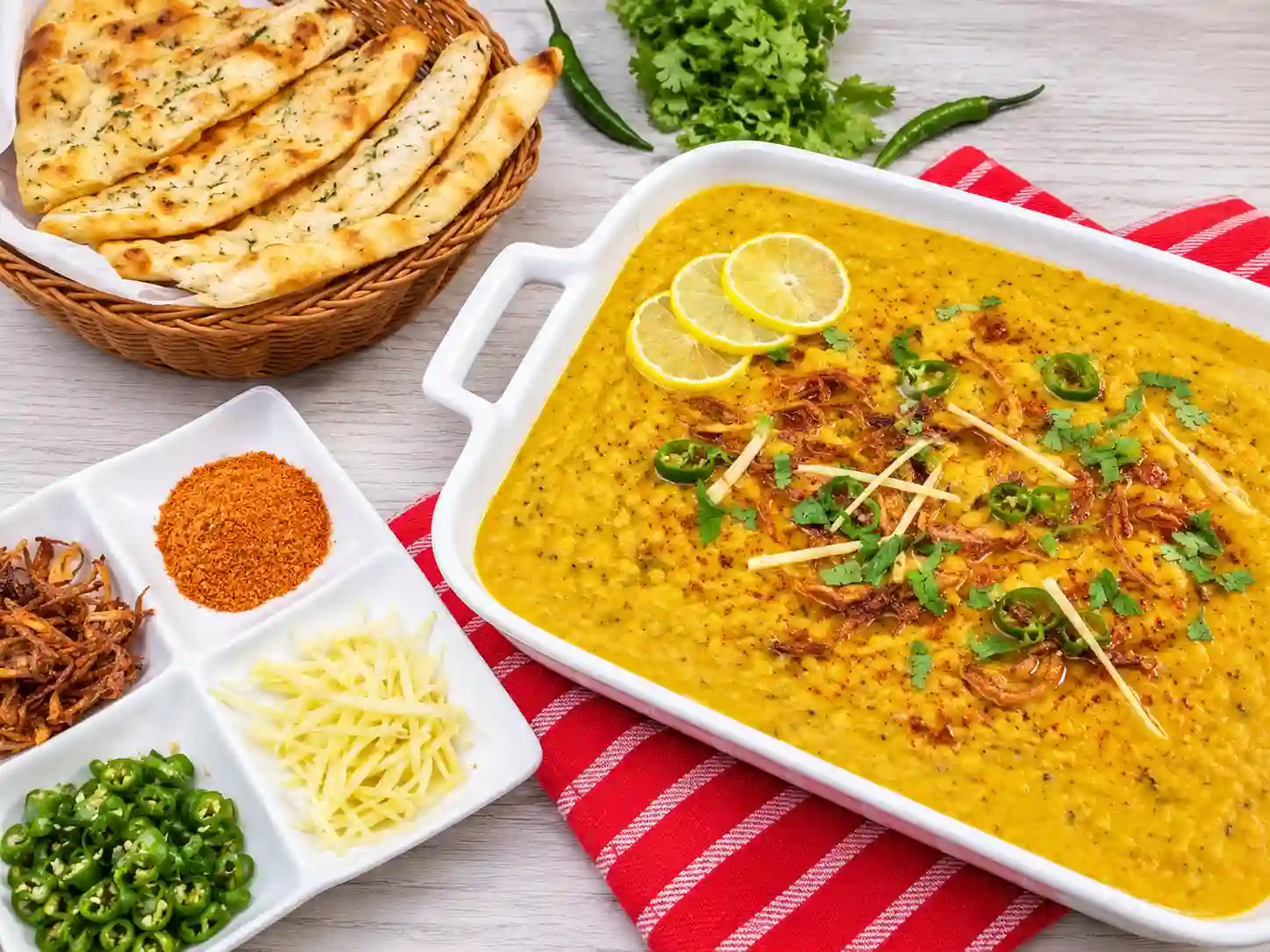A bowl of haleem with traditional garnishes